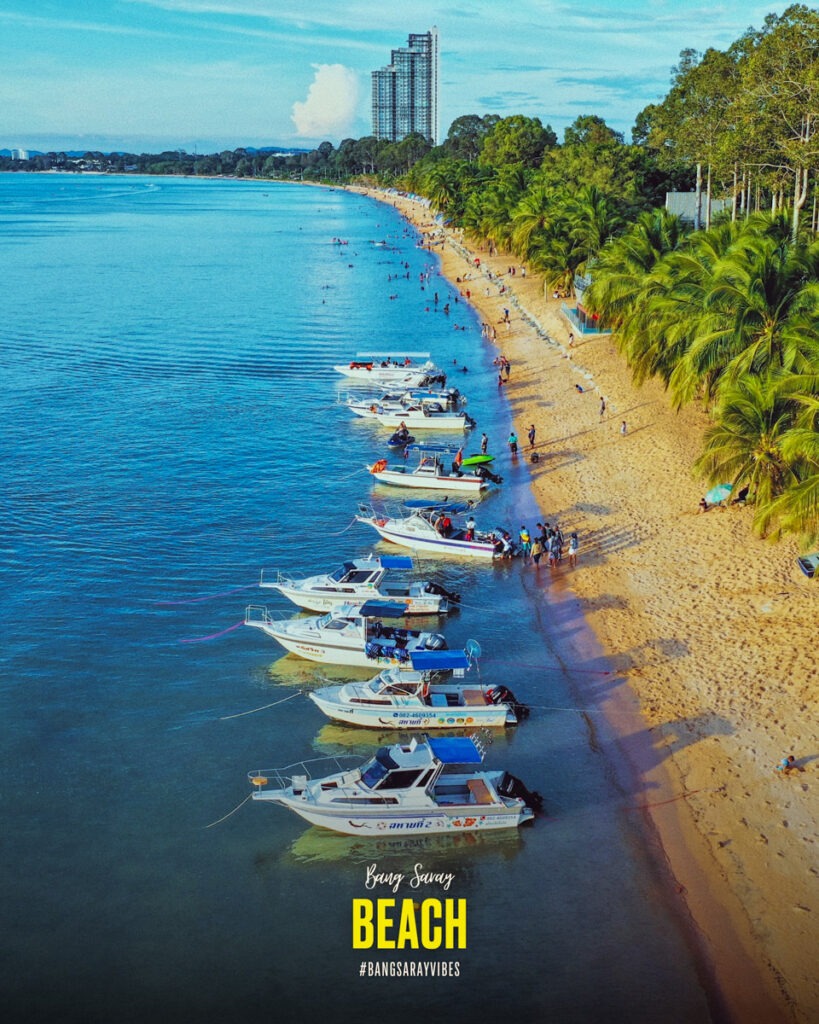 The image is of a beach in Bang Saray with boats and people. It features a scenic view of the shore with blue waters, boats, and a clear sky. The tags associated with the image include outdoor, water, tree, sky, boat, and beach.