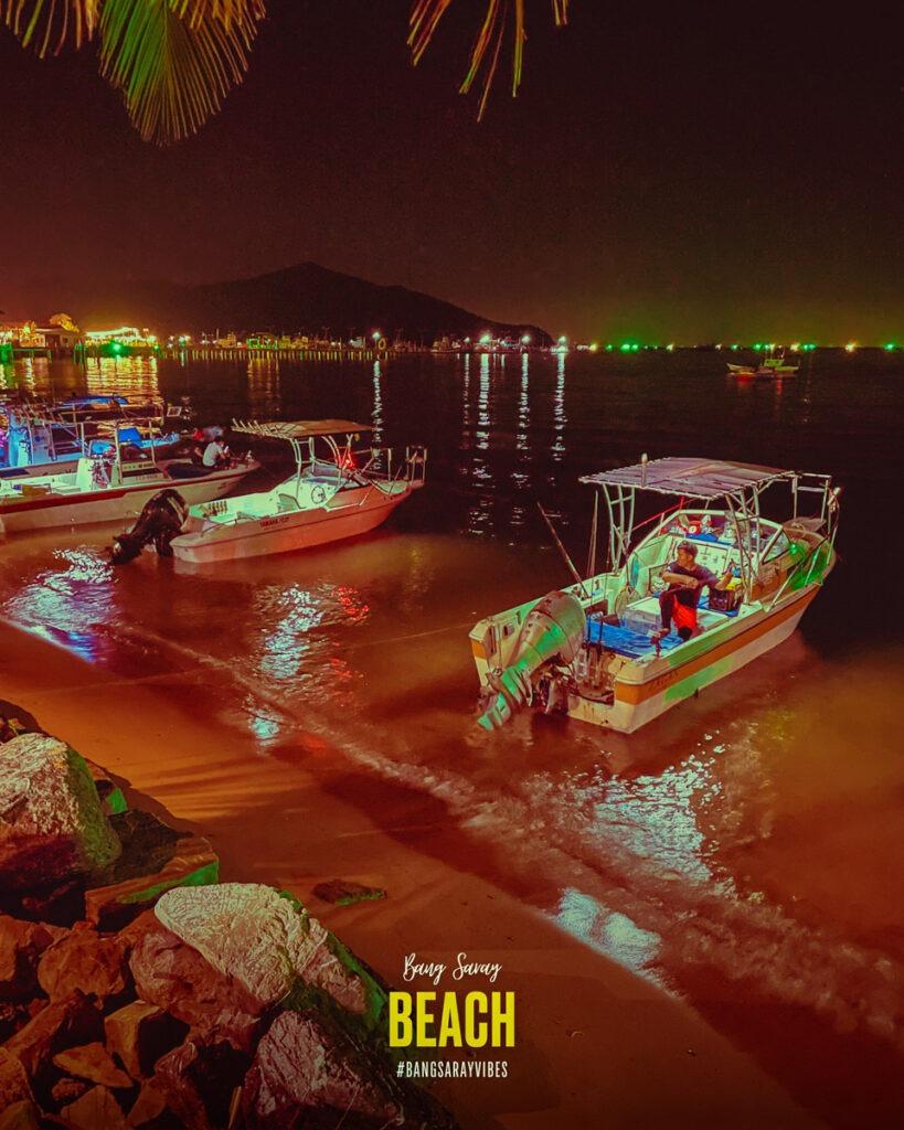 The image shows boats on the water of Bang Saray beach at the night.