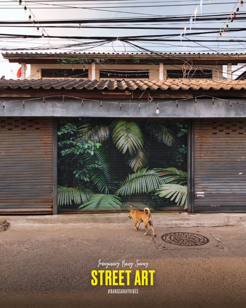 A tropical jungle mural adorns the steel rolling doors in Bang Saray Old Town, Thailand.